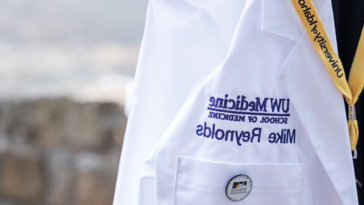 A close-up of Mike Reynolds’ name on his white coat.